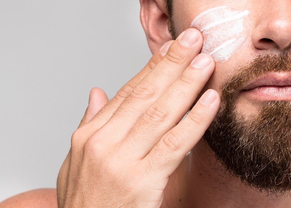 hombre poniéndose crema para la cara en primer plano