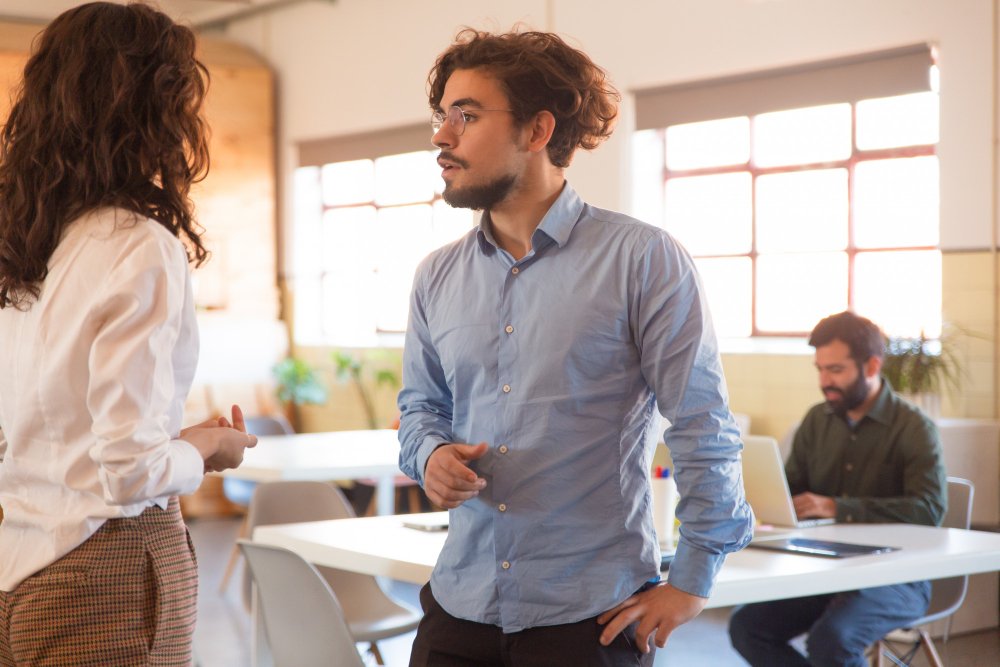 hombre joven hablando con una chica en un coworking