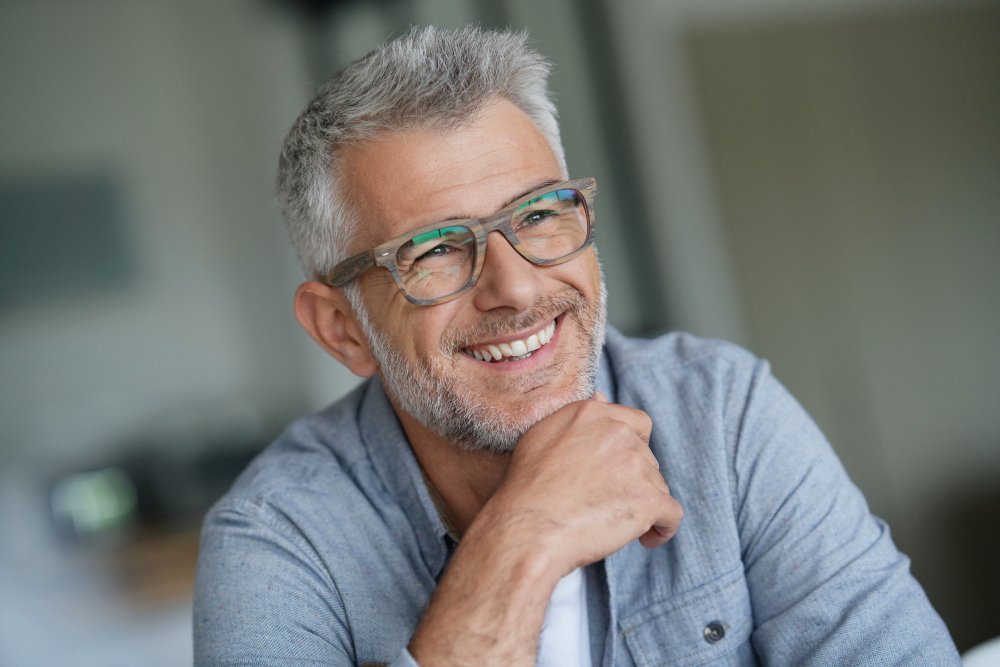 hombre sonriendo con gafas y barba blanca